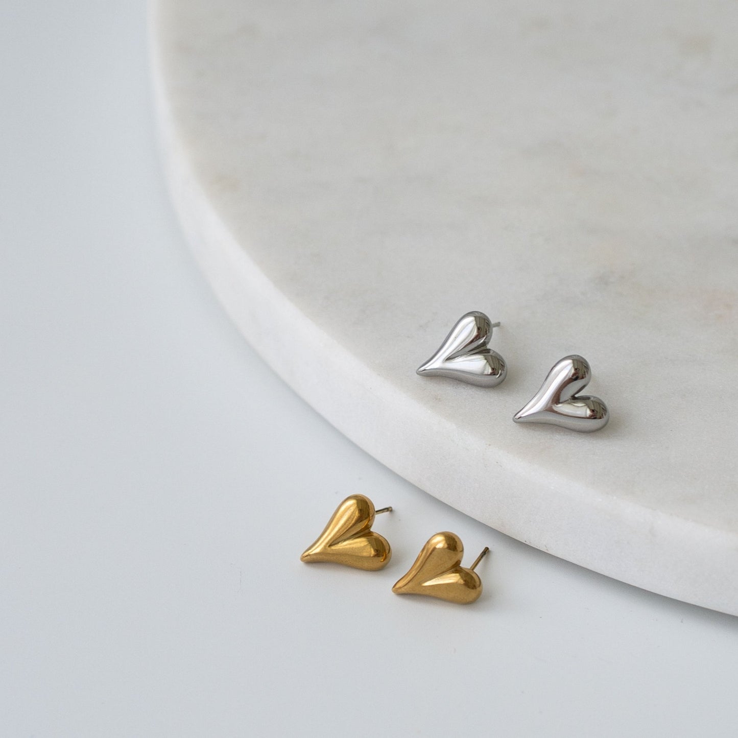 Heart-shaped stud earrings in gold and silver finishes, a timeless and meaningful gift for any occasion.
