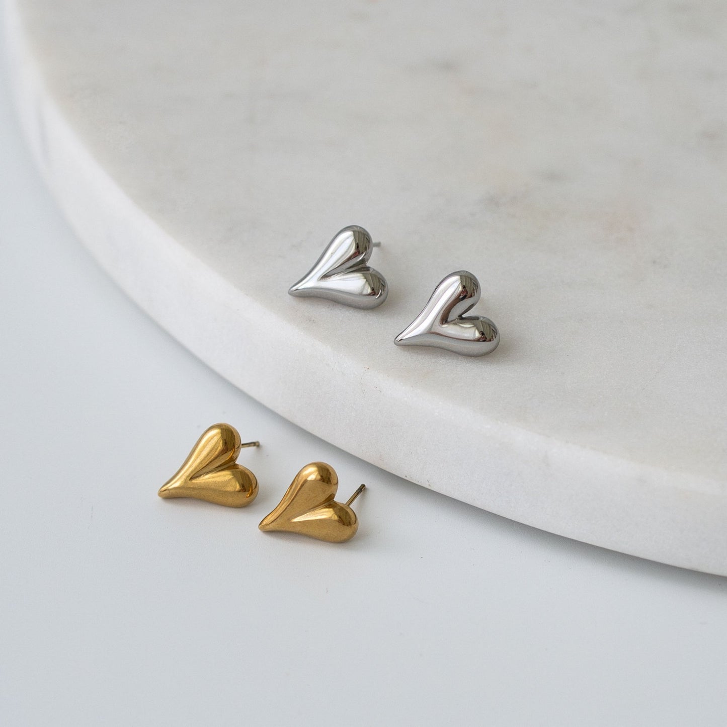 Heart-shaped stud earrings in gold and silver finishes, a timeless and meaningful gift for any occasion.