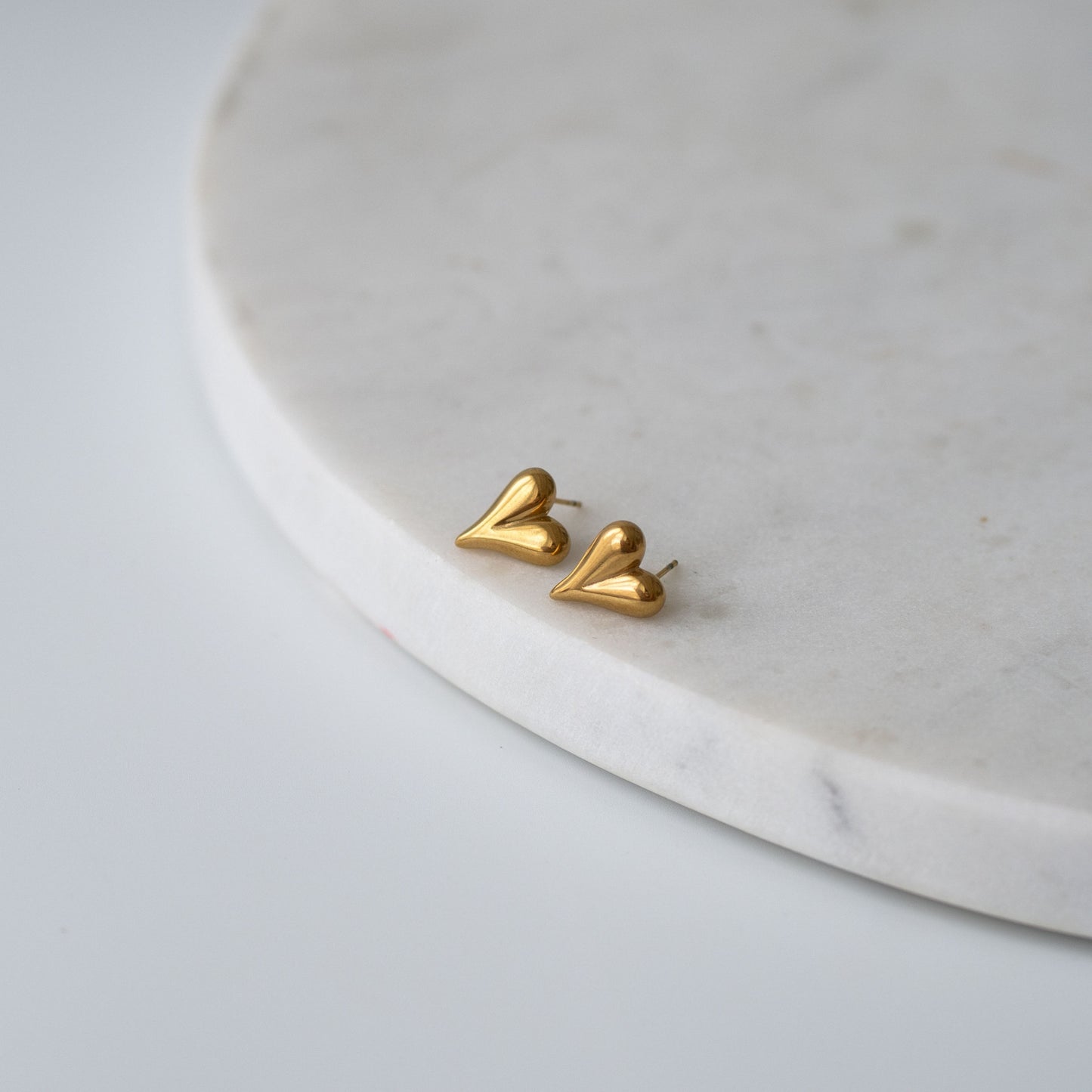 Heart-shaped stud earrings in gold and silver finishes, a timeless and meaningful gift for any occasion.